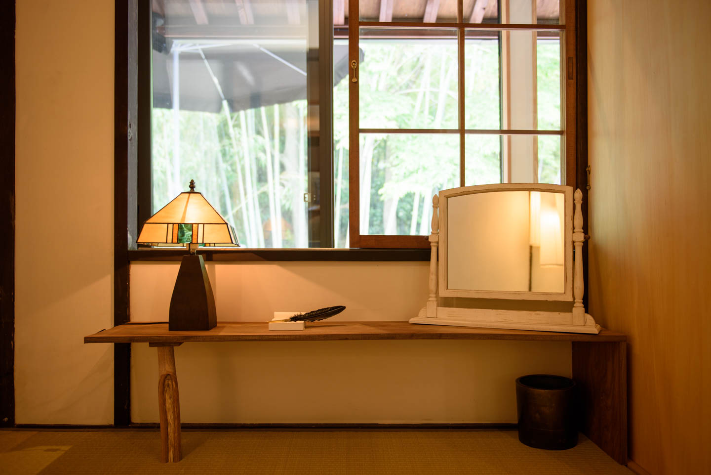 朝日が差し込み、窓から竹やぶの見える寝室